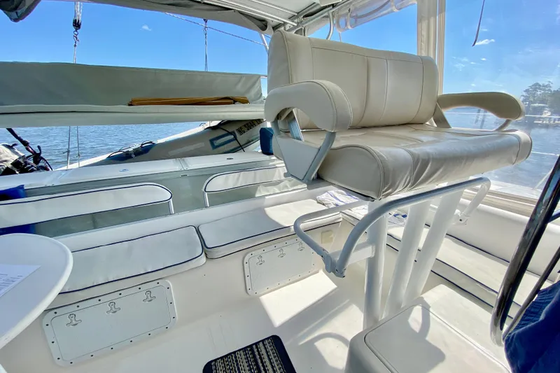 Slide: The Image of 1998 Manta 40 yacht interior with white seating and helm, overlooking serene waters. - 10