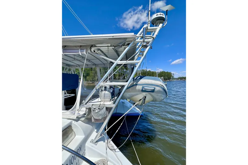 Slide: The Image of Sailboat Manta 40 (1998) with dinghy, docked on a sunny day by the water. - 103