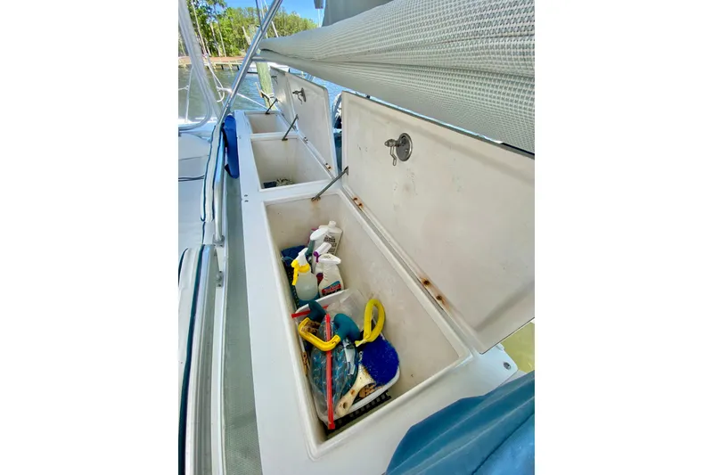 Slide: The Image of Open storage compartment on 1998 Manta 40 boat, containing cleaning supplies and tools. - 11