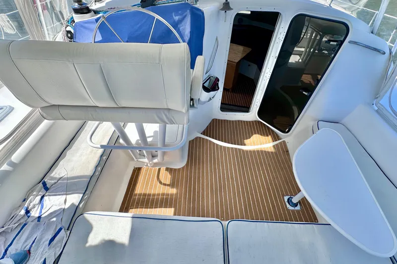 Slide: The Image of 1998 Manta 40 yacht cockpit with white seating and wooden flooring. - 110