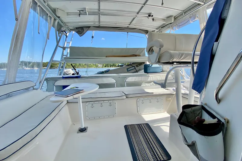 Slide: The Image of Interior view of a 1998 Manta 40 catamaran, featuring seating and a scenic water backdrop. - 14