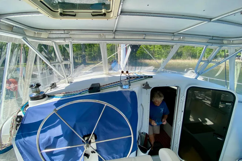 Slide: The Image of Interior view of a 1998 Manta 40 sailboat cockpit with a person entering the cabin. - 15