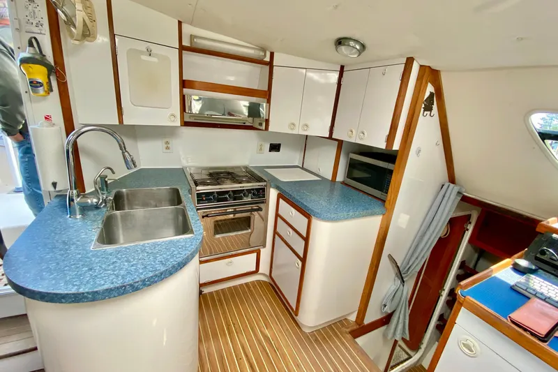 Slide: The Image of Modern kitchen in a 1998 Manta 40 yacht with blue countertops and wood accents. - 18
