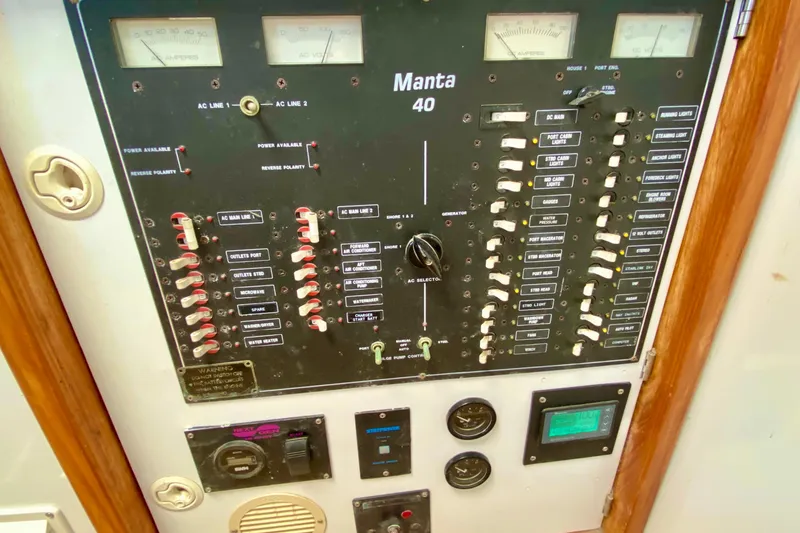 Slide: The Image of Electrical control panel of a 1998 Manta 40 boat with switches and gauges. - 23