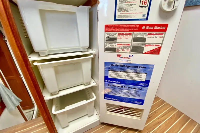 Slide: The Image of Waste management area on a 1998 Manta 40 boat with storage bins and safety notices. - 28