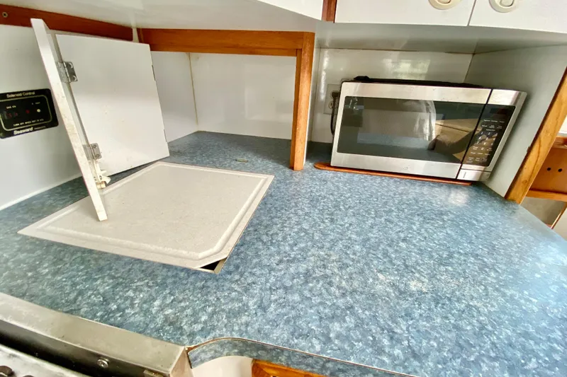 Slide: The Image of 1998 Manta 40 yacht kitchen with microwave and blue countertop. - 30