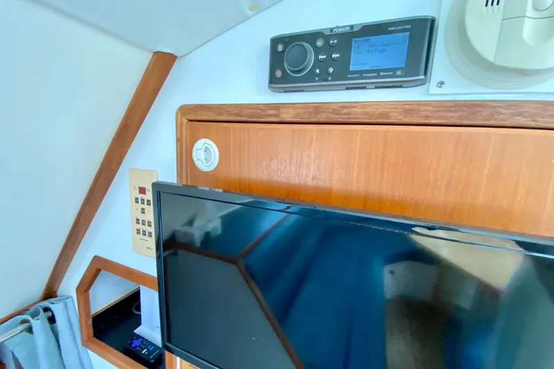Slide: The Image of Interior of a 1998 Manta 40 yacht featuring a mounted TV and audio system. - 32