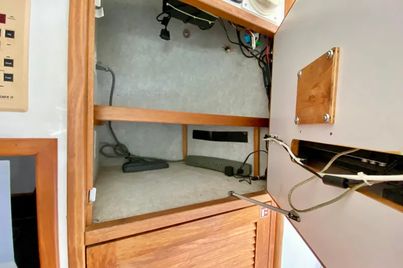 Slide: The Image of Interior view of a 1998 Manta 40 yacht cabinet with wiring and storage space. - 33