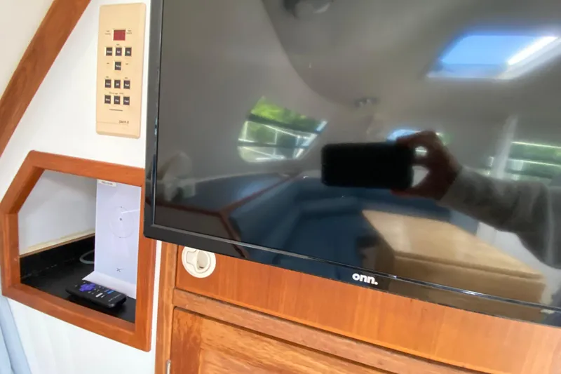 Slide: The Image of Interior of a 1998 Manta 40 yacht featuring a mounted TV and control panel. - 36