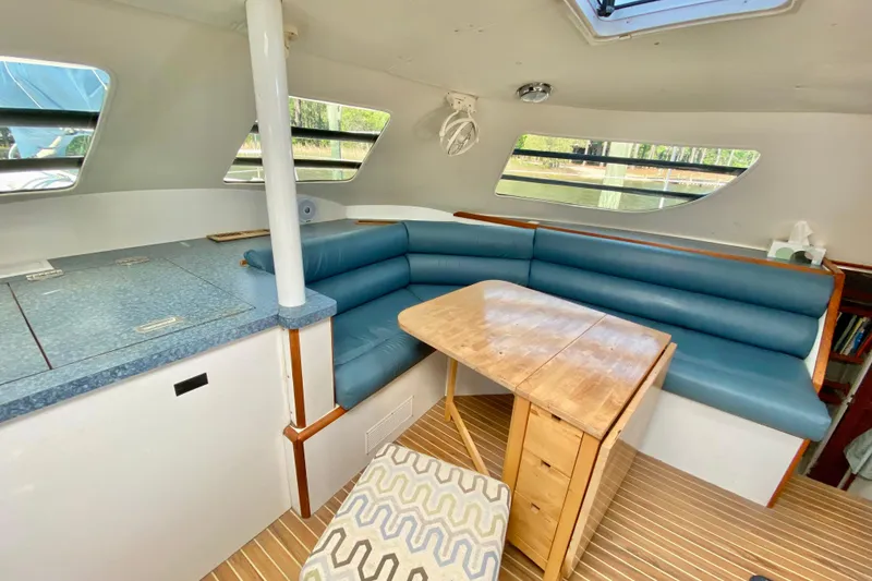Slide: The Image of Interior of a 1998 Manta 40 yacht with blue seating and wooden table. - 43