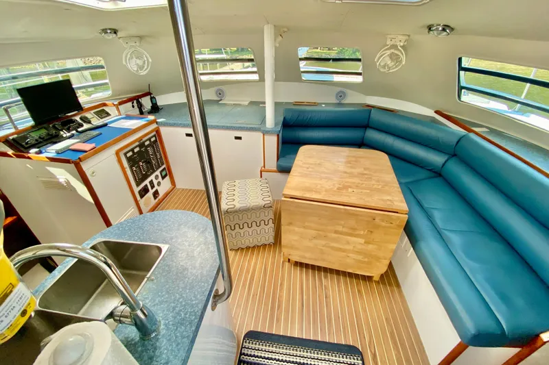 Slide: The Image of Interior of 1998 Manta 40 yacht with blue seating and wooden table. - 44