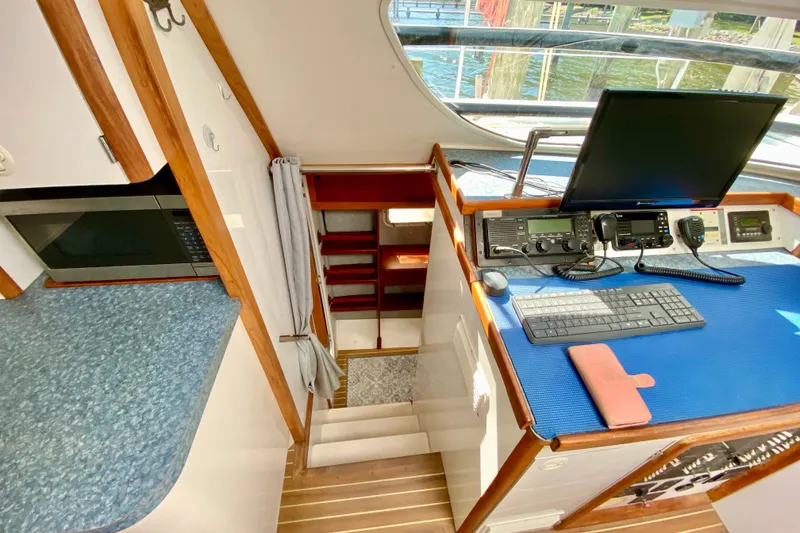 Slide: The Image of Interior of a 1998 Manta 40 yacht featuring navigation equipment and a compact kitchen area. - 46