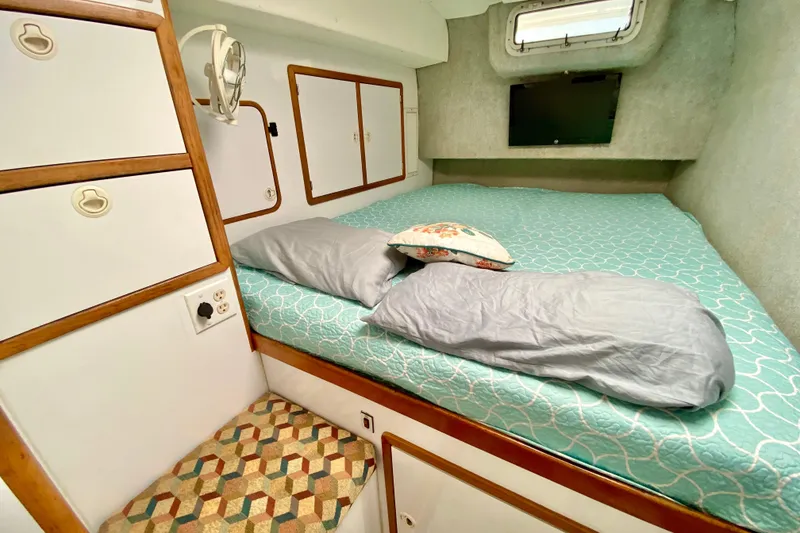 Slide: The Image of Cozy cabin interior of 1998 Manta 40 yacht with bed, storage, and window. - 49