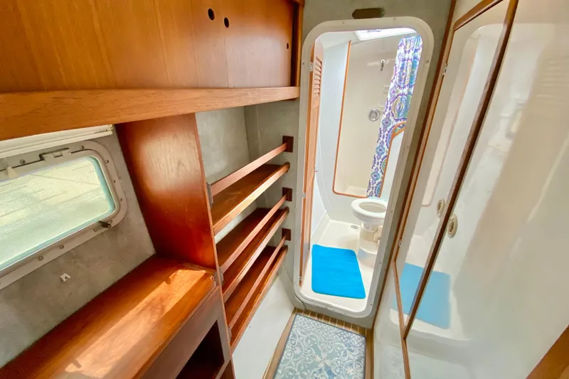 Slide: The Image of Interior of 1998 Manta 40 yacht featuring wooden shelves and compact bathroom. - 51