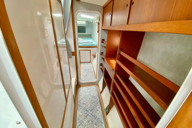 Slide: The Image of Narrow hallway in 1998 Manta 40 yacht with wooden shelves and cozy bedroom view. - 52