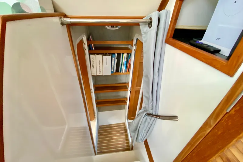 Slide: The Image of Interior of 1998 Manta 40 sailboat with wooden stairs and bookshelf. - 58
