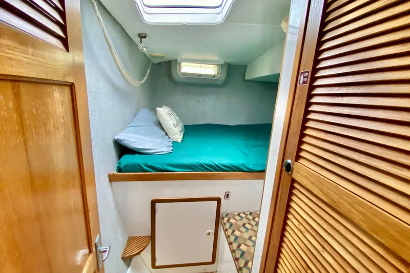Slide: The Image of Cozy cabin interior of 1998 Manta 40 sailboat with bed and wooden accents. - 59