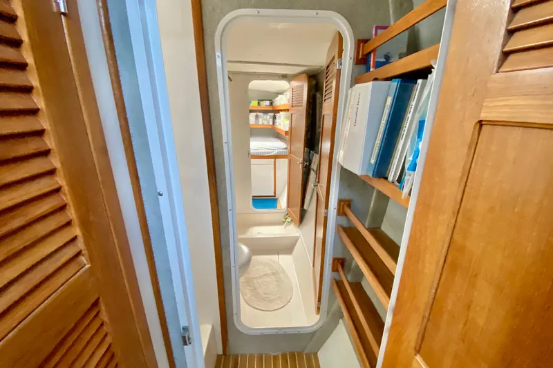 Slide: The Image of Narrow hallway inside 1998 Manta 40 yacht with wooden shelves and door. - 61