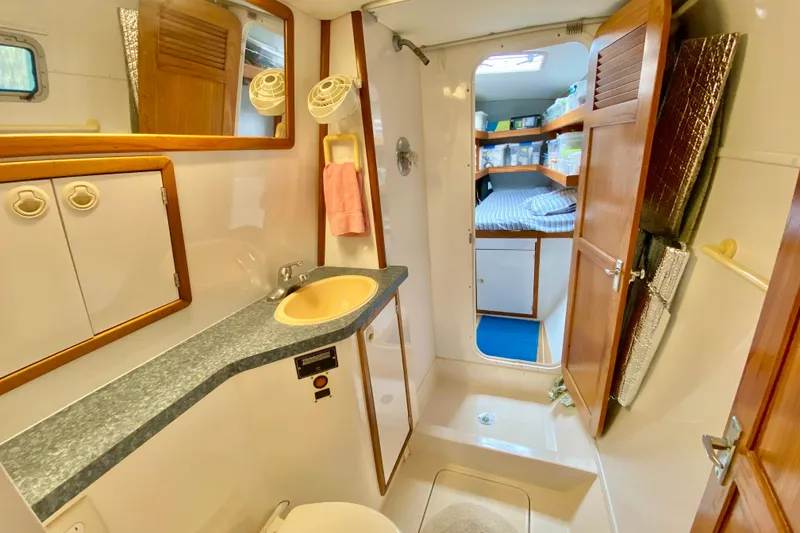 Slide: The Image of Bathroom interior of 1998 Manta 40 yacht, featuring sink, mirror, and cabin view. - 62