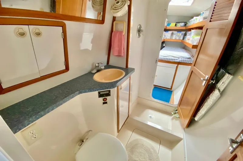 Slide: The Image of 1998 Manta 40 yacht bathroom with sink, mirror, and storage cabinets. - 68