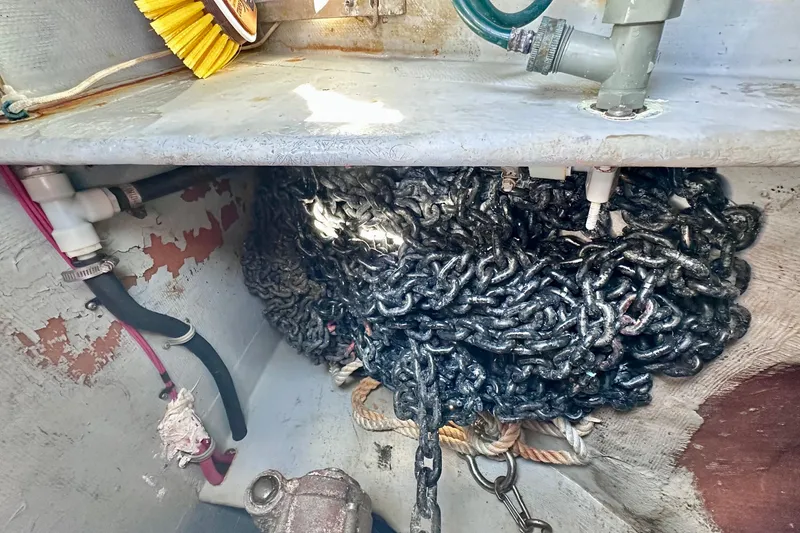 Slide: The Image of Anchor chain storage in a 1998 Manta 40 sailboat, featuring ropes and plumbing components. - 95