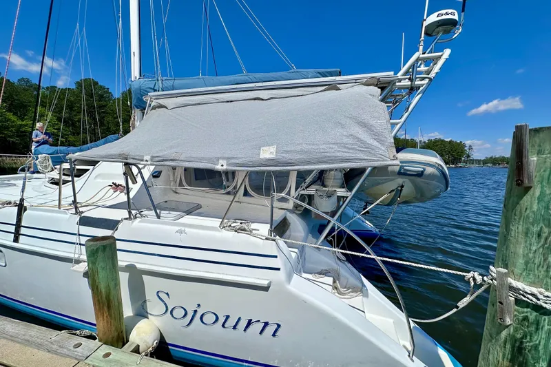 Slide: The Image of Sailboat "Sojourn" docked, Manta 40 model, 1998, with blue sky and water backdrop. - 99