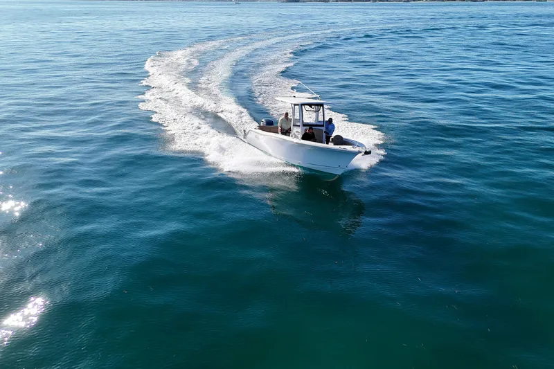 Slide: The Image of 2018 Sea Hunt Ultra 255 SE cruising on open water, leaving a wake trail. - 2
