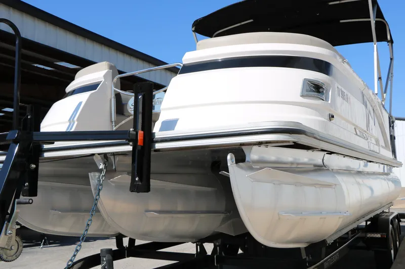 Slide: The Image of 2020 Silver Wave 2210 SW5 L pontoon boat on trailer, under clear blue sky. - 14