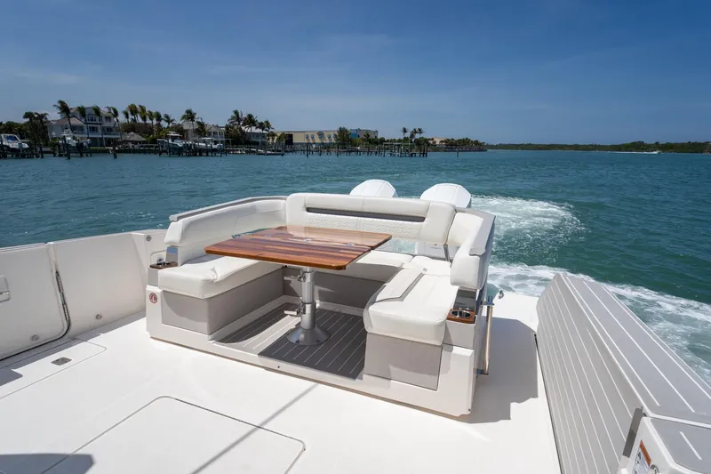 Slide: The Image of 2024 Tiara Yachts 43 LS luxury yacht with elegant seating and wooden table on open water. - 11