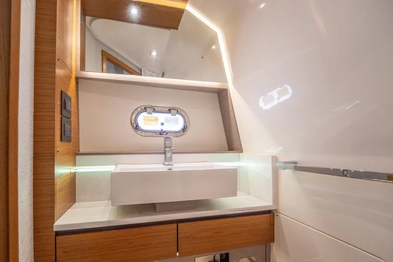 Slide: The Image of Luxurious bathroom interior of 2024 Tiara Yachts 43 LS, featuring modern sink and porthole window. - 16