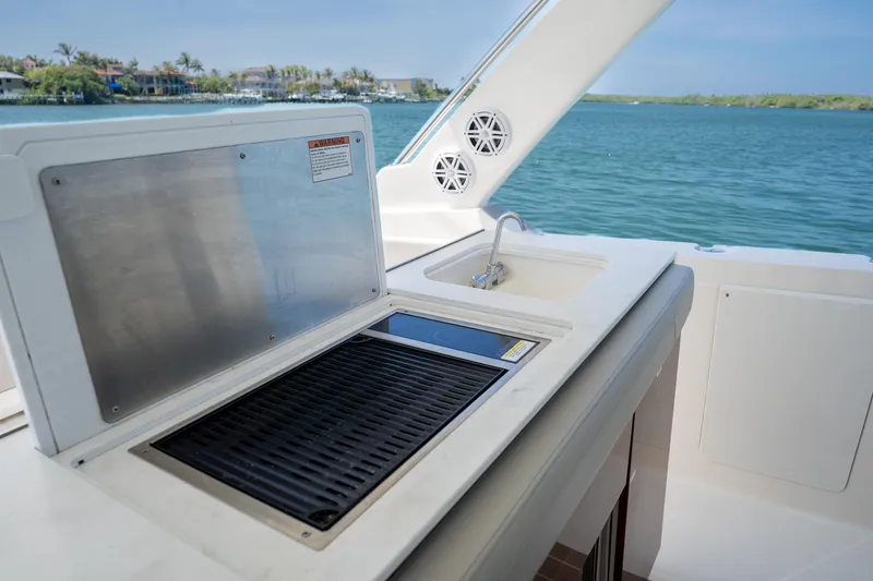 Slide: The Image of Outdoor kitchen on 2024 Tiara Yachts 43 LS, featuring grill and sink by the water. - 20