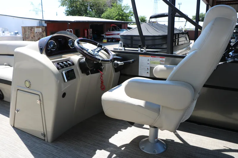 Slide: The Image of Captain's chair and helm of 2019 Berkshire 22CL CTS pontoon boat, featuring steering wheel and controls. - 30