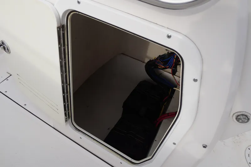Slide: The Image of Open storage compartment on a 2015 Edgewater 170CC boat, showing wiring and equipment. - 9