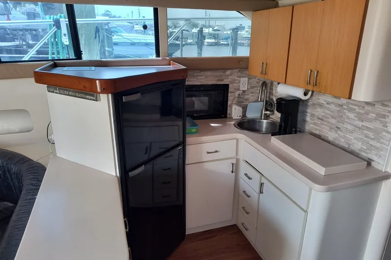 Slide: The Image of 1996 Mainship 40 Sedan Bridge interior kitchen with modern appliances and wood cabinetry. - 11