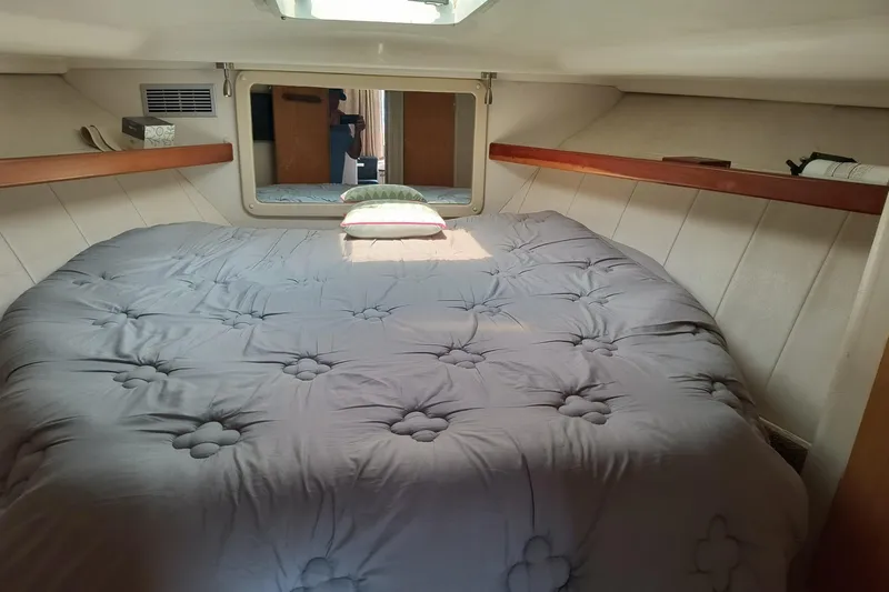 Slide: The Image of Cozy cabin interior of 1996 Mainship 40 Sedan Bridge with plush bedding and mirror. - 13