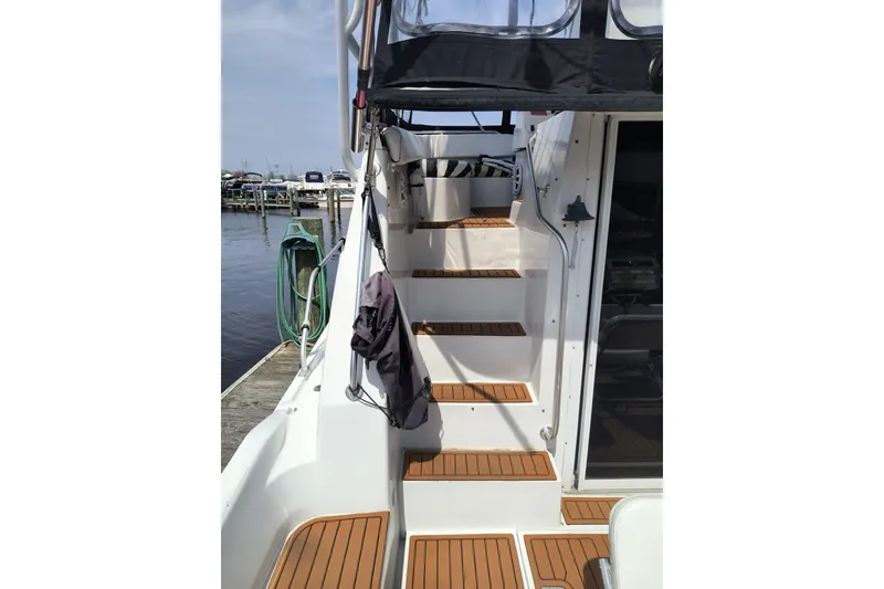 Slide: The Image of 1996 Mainship 40 Sedan Bridge boat with wooden steps and dockside view. - 5