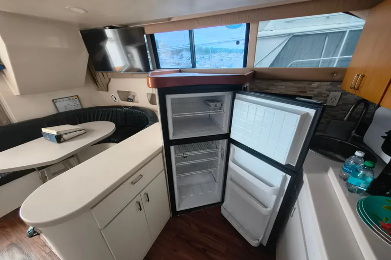 Slide: The Image of Interior of 1996 Mainship 40 Sedan Bridge with open fridge and dining area. - 14