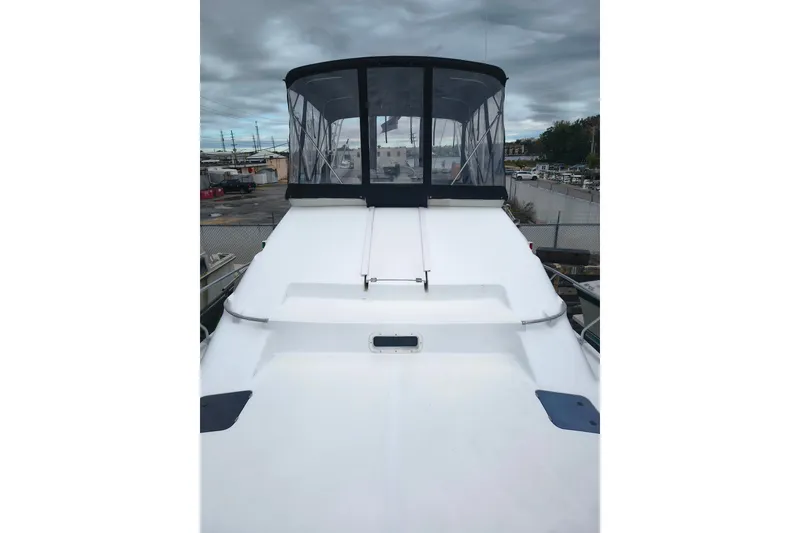 Slide: The Image of 1996 Mainship 40 Sedan Bridge yacht with enclosed flybridge, docked under cloudy skies. - 20