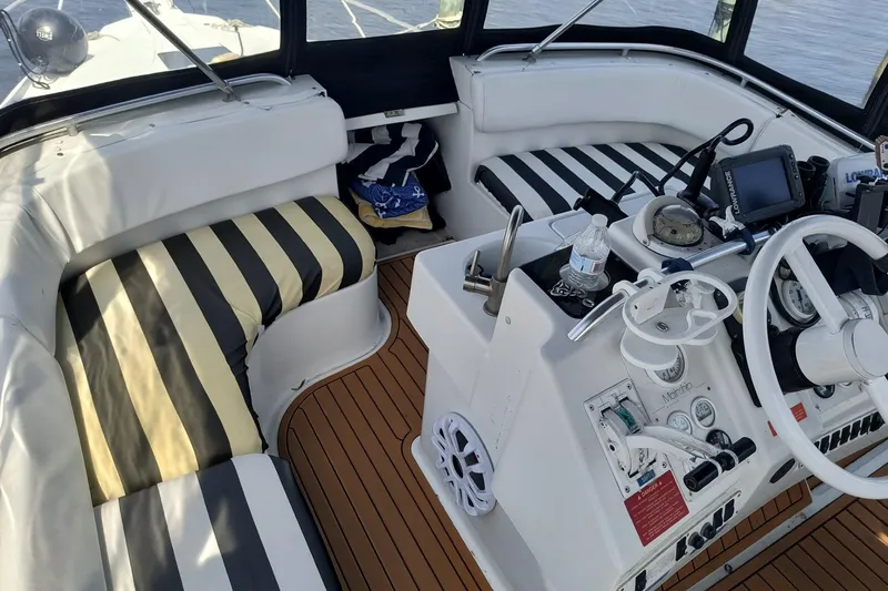 Slide: The Image of 1996 Mainship 40 Sedan Bridge helm with striped seating and navigation equipment. - 8