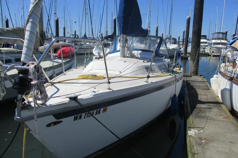 The Image of 1978 Catalina 30 sailboat docked in a marina, surrounded by other boats. - 1