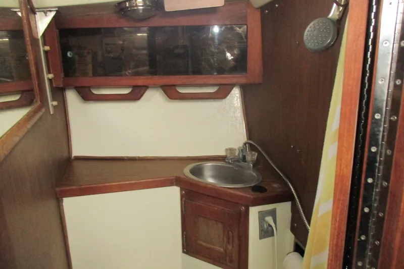Slide: The Image of 1978 Catalina 30 yacht bathroom with wooden cabinetry and stainless steel sink. - 13
