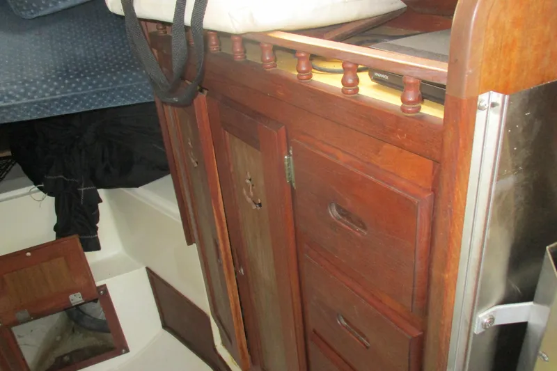 Slide: The Image of Interior of a 1978 Catalina 30 sailboat featuring wooden cabinetry and storage compartments. - 14