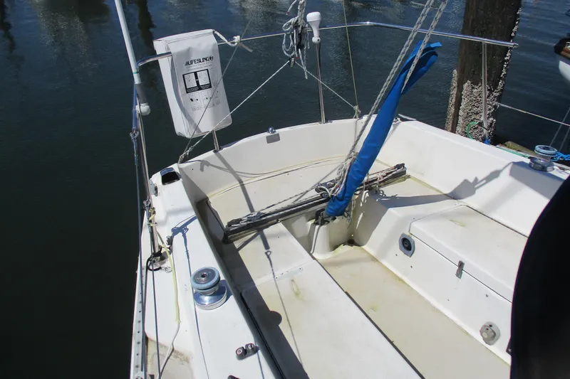 Slide: The Image of 1978 Catalina 30 sailboat cockpit with lifeline and winch, docked by the water. - 4
