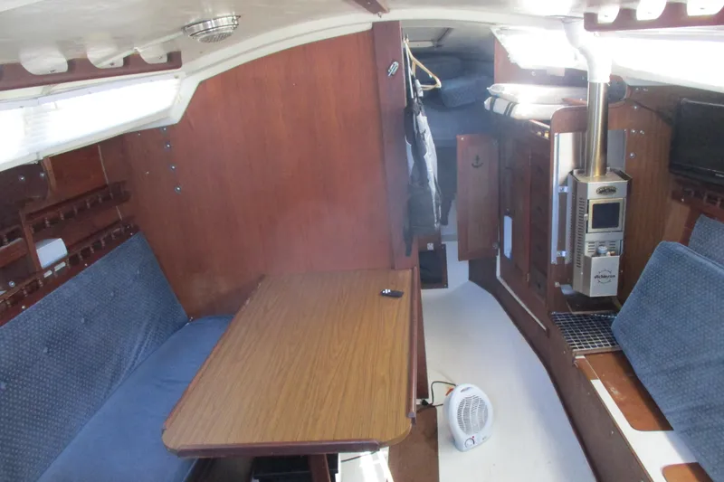 Slide: The Image of Interior of a 1978 Catalina 30 sailboat with wood paneling and blue seating. - 6