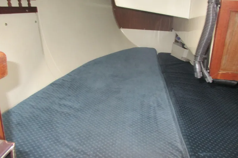 Slide: The Image of Interior cabin view of a 1978 Catalina 30 sailboat with blue bedding. - 9