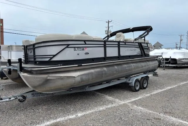 Slide: The Image of 2021 Starcraft SLS 3 pontoon boat on a trailer in a parking lot. - 1