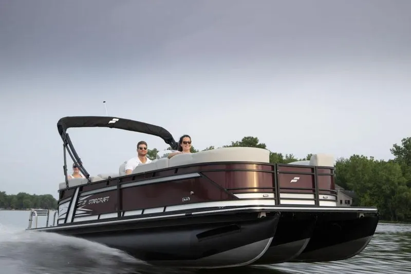 Slide: The Image of 2021 Starcraft SLS 3 pontoon boat with luxurious seating and sleek design in a marina setting. - 12
