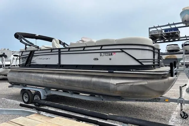 Slide: The Image of 2021 Starcraft SLS 3 pontoon boat on trailer in parking lot. - 2