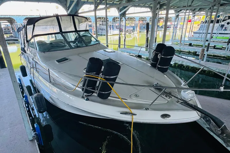 Slide: The Image of 2001 Sea Ray Sundancer 310 docked in a covered marina, showcasing sleek design and spacious deck. - 10