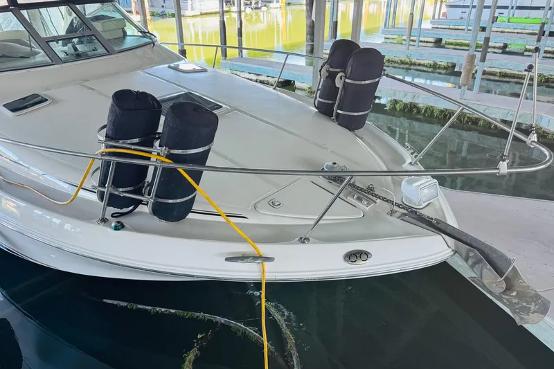 Slide: The Image of 2001 Sea Ray Sundancer 310 docked, featuring bow with fenders and anchor. - 11